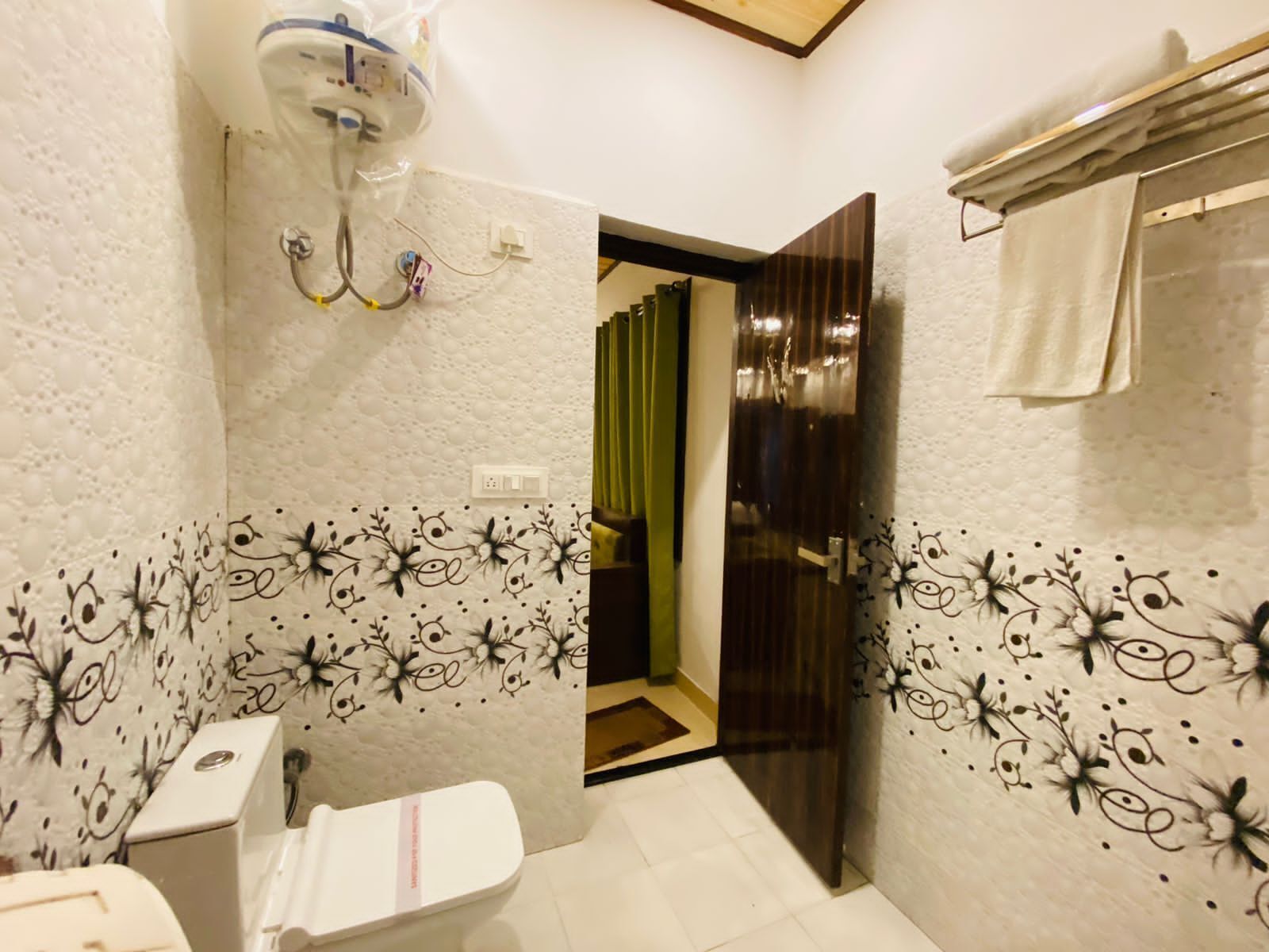 Une salle de bain comprenant des toilettes, un espace douche et un porte-serviettes.