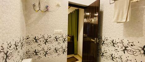 Une salle de bain comprenant des toilettes, un espace douche et un porte-serviettes.
