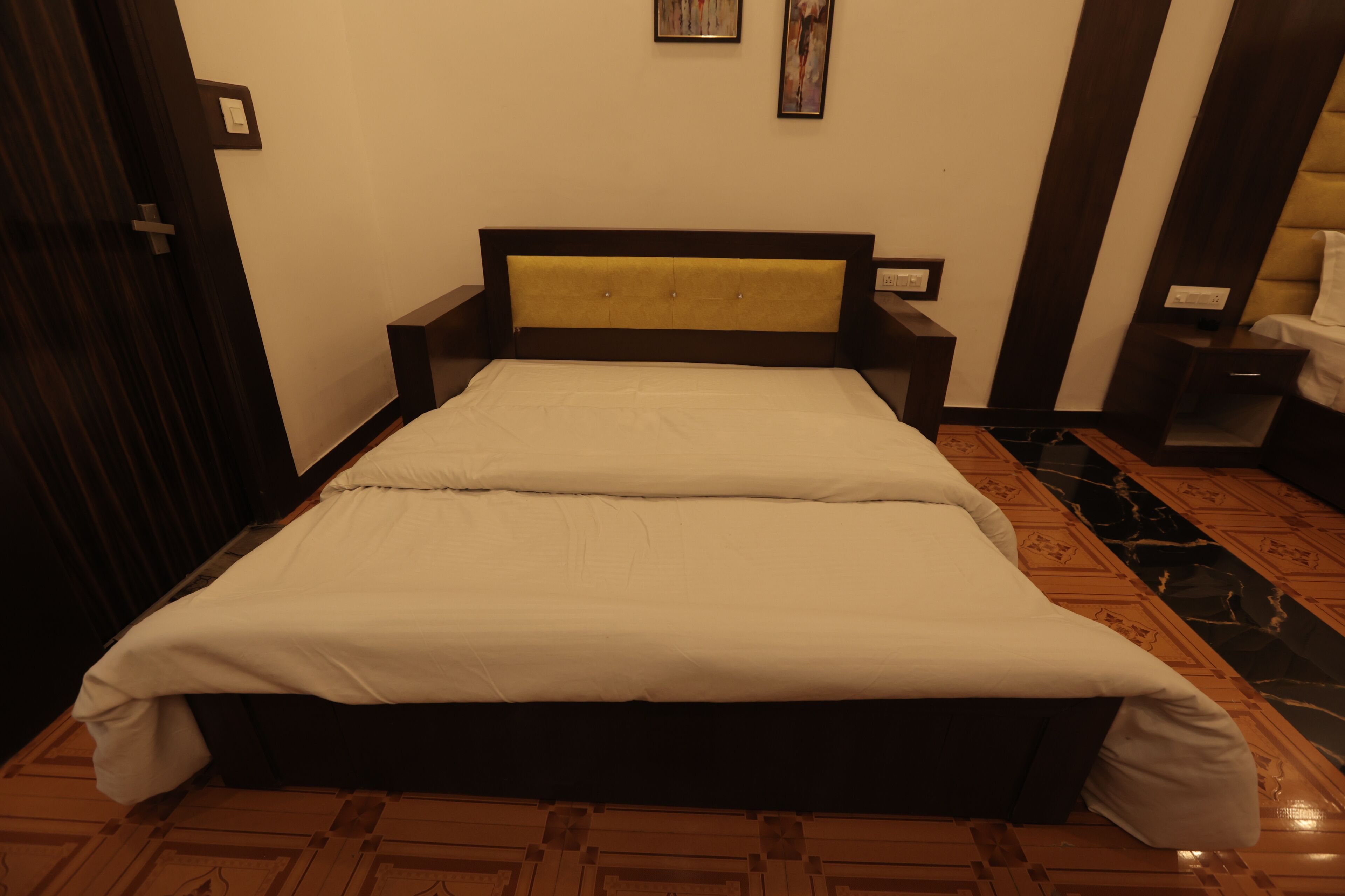 A neatly made bed with a wooden headboard, a bedside table, and a nightstand.