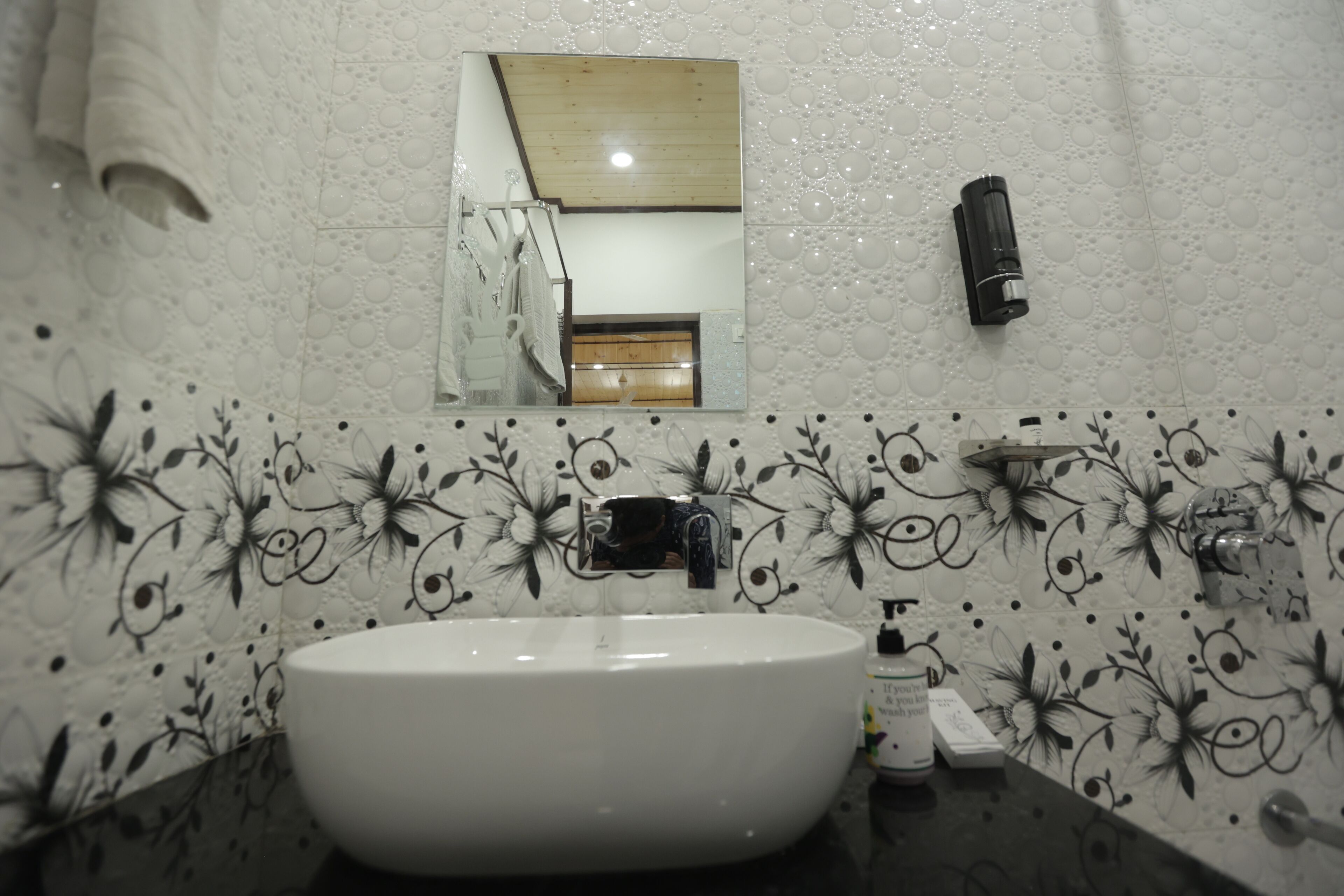 A bathroom with a white sink, a mirror, and a towel rack.