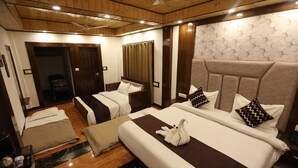 A hotel room with two beds, a sitting area, and a wooden ceiling. - StudioZ Paradise Hills Mussoorie (Mussoorie)