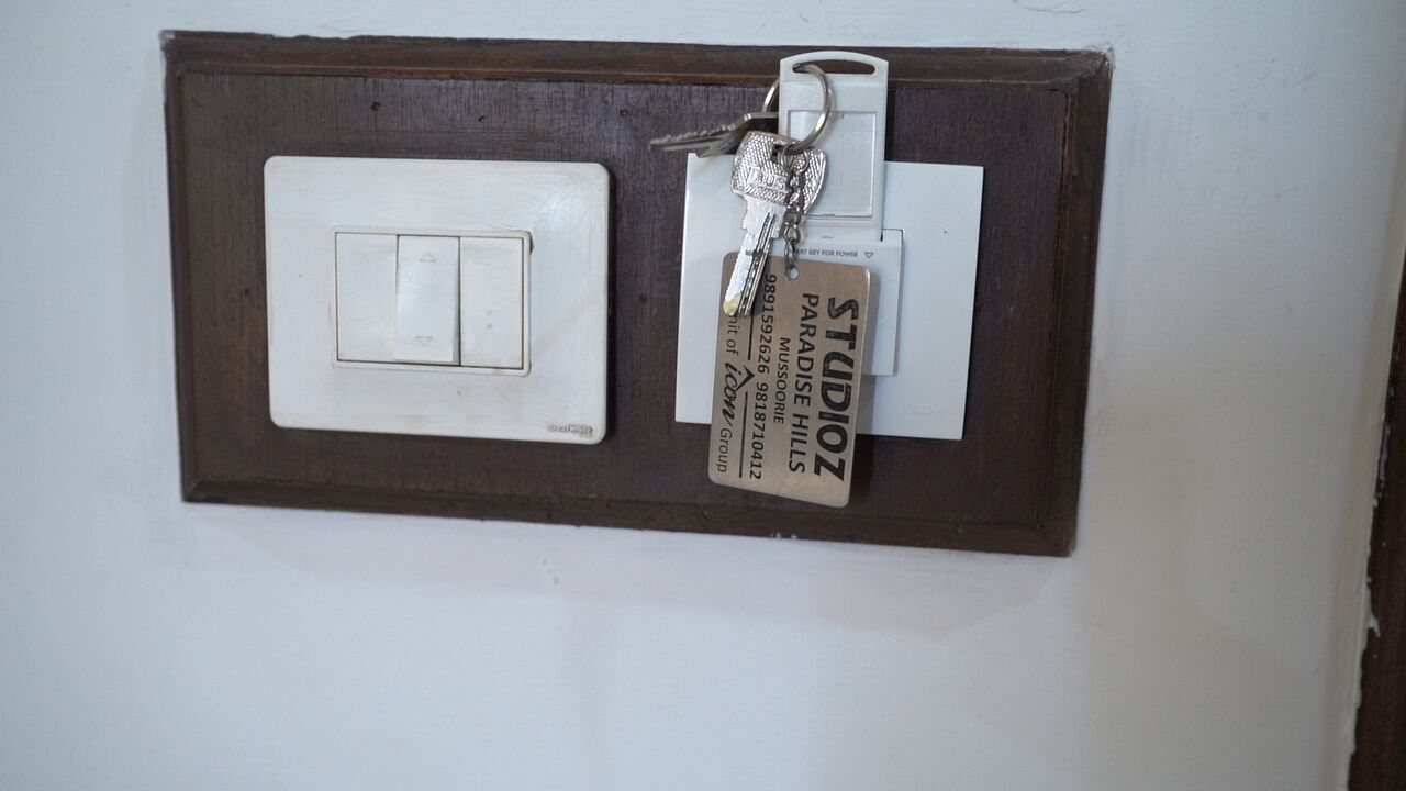 A wall-mounted light switch and a key tag with a nameplate.