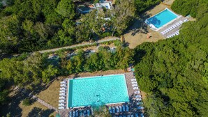An aerial view of a resort with two swimming pools surrounded by lush greenery. - HappyCamp in Camping Baia Paradiso (Badesi)