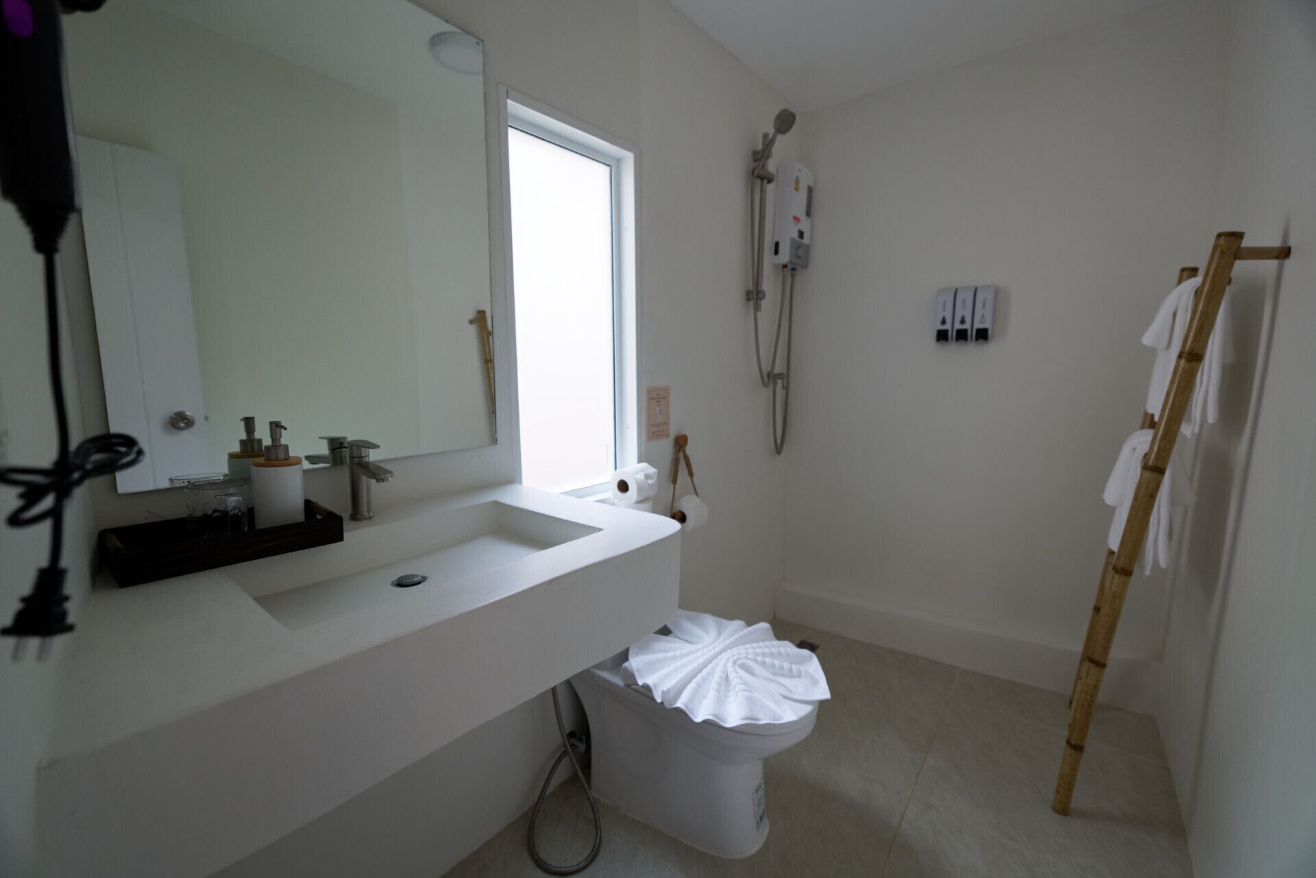 Ein Badezimmer mit weißem Waschbecken, Spiegel, Toilette und Dusche.