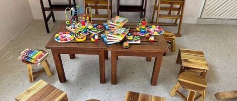 A room with wooden furniture including a table, chairs, and stools.