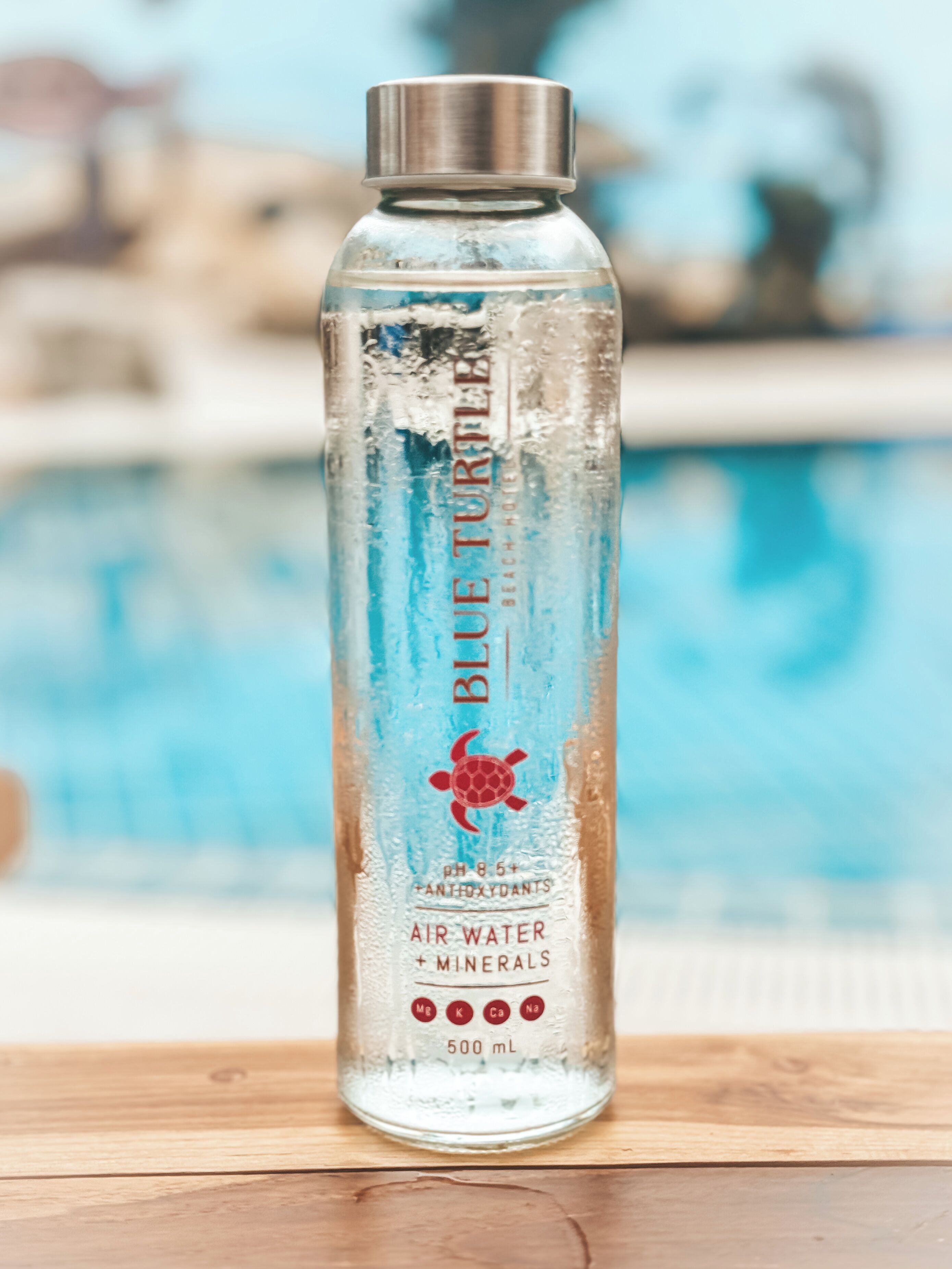Una botella de agua aire Blue Turtle con minerales junto a la piscina.