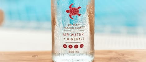 Una botella de agua aire Blue Turtle con minerales junto a la piscina.