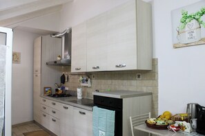 A kitchen with light-colored cabinets, a stainless steel sink, and a countertop with various items. - Fior d'Olivo – Apartment with a pool near the sea in Sestri Levante (Sestri Levante)