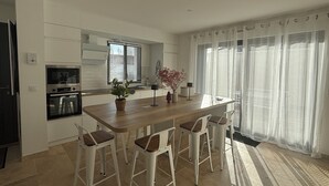 Eine moderne Küche mit Kochinsel, Barhocker und Essbereich.