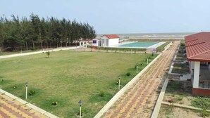 A hotel with a swimming pool, a tennis court, and a large grassy area. - Tarangamala Resort (Kanthi)
