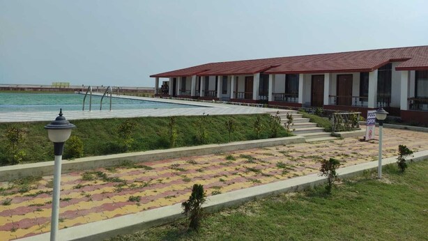 A building with a red-tiled roof and a pool area. - Tarangamala Resort (Kanthi)