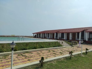 A building with a red-tiled roof and a pool area. - Tarangamala Resort (Kanthi)