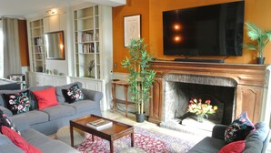 A living room with a fireplace, sofas, a coffee table, and a television.