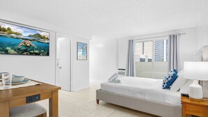 Een moderne hotelkamer met een bed, nachtkastje en een televisie waarop een zeeschildpad wordt getoond.