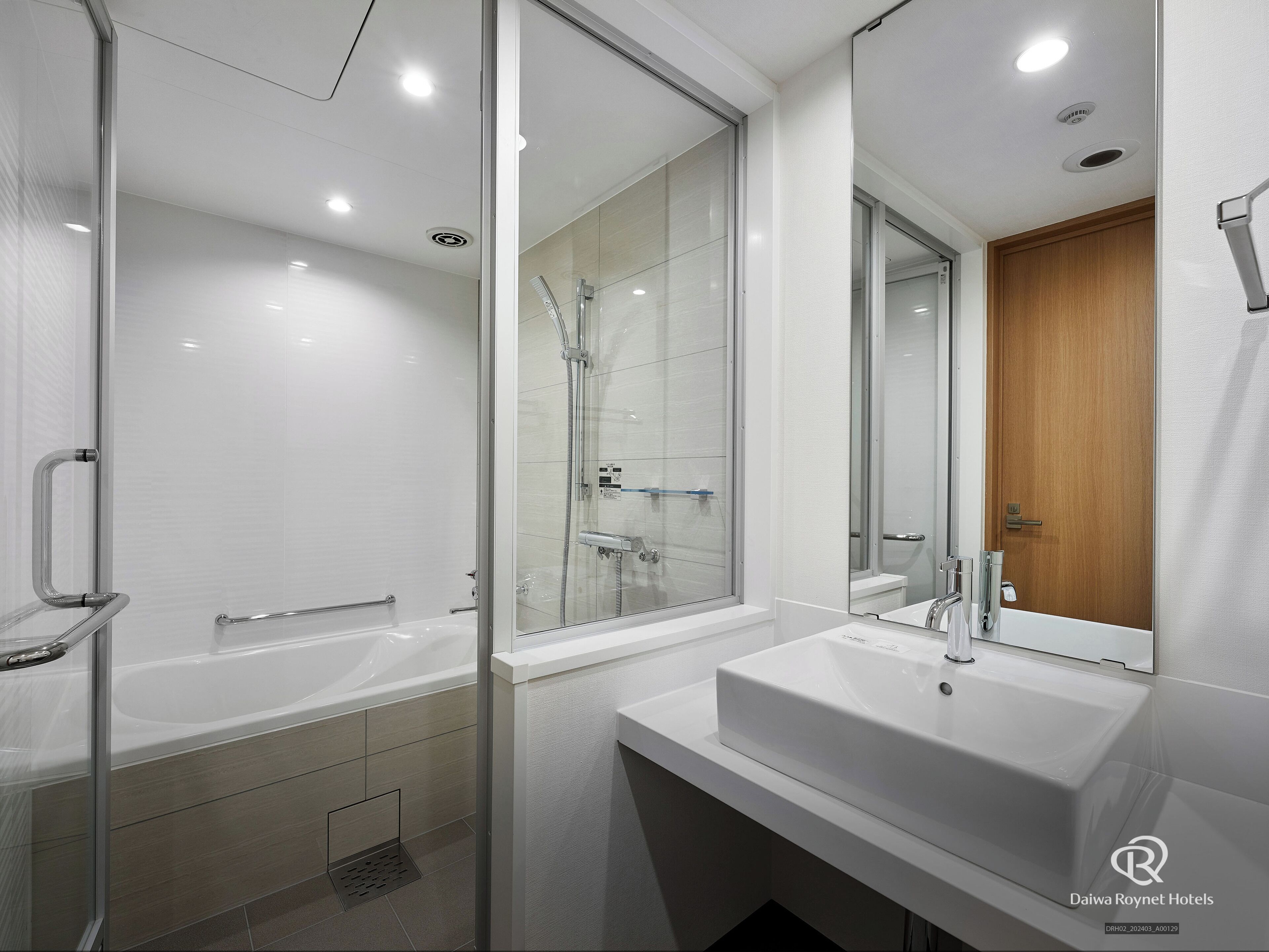 Un baño moderno con ducha de vidrio, una bañera independiente y un tocador con lavamanos.