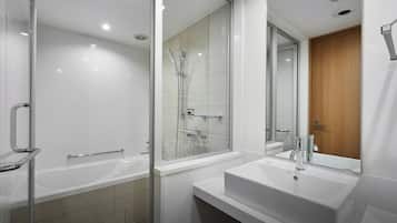 A modern bathroom with a glass-enclosed shower, a standalone bathtub, and a vanity with a sink.