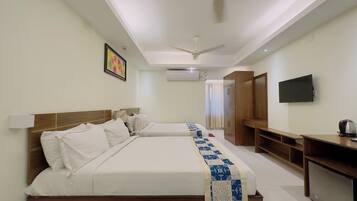 A hotel room with two beds, a TV, a desk, and a wardrobe.