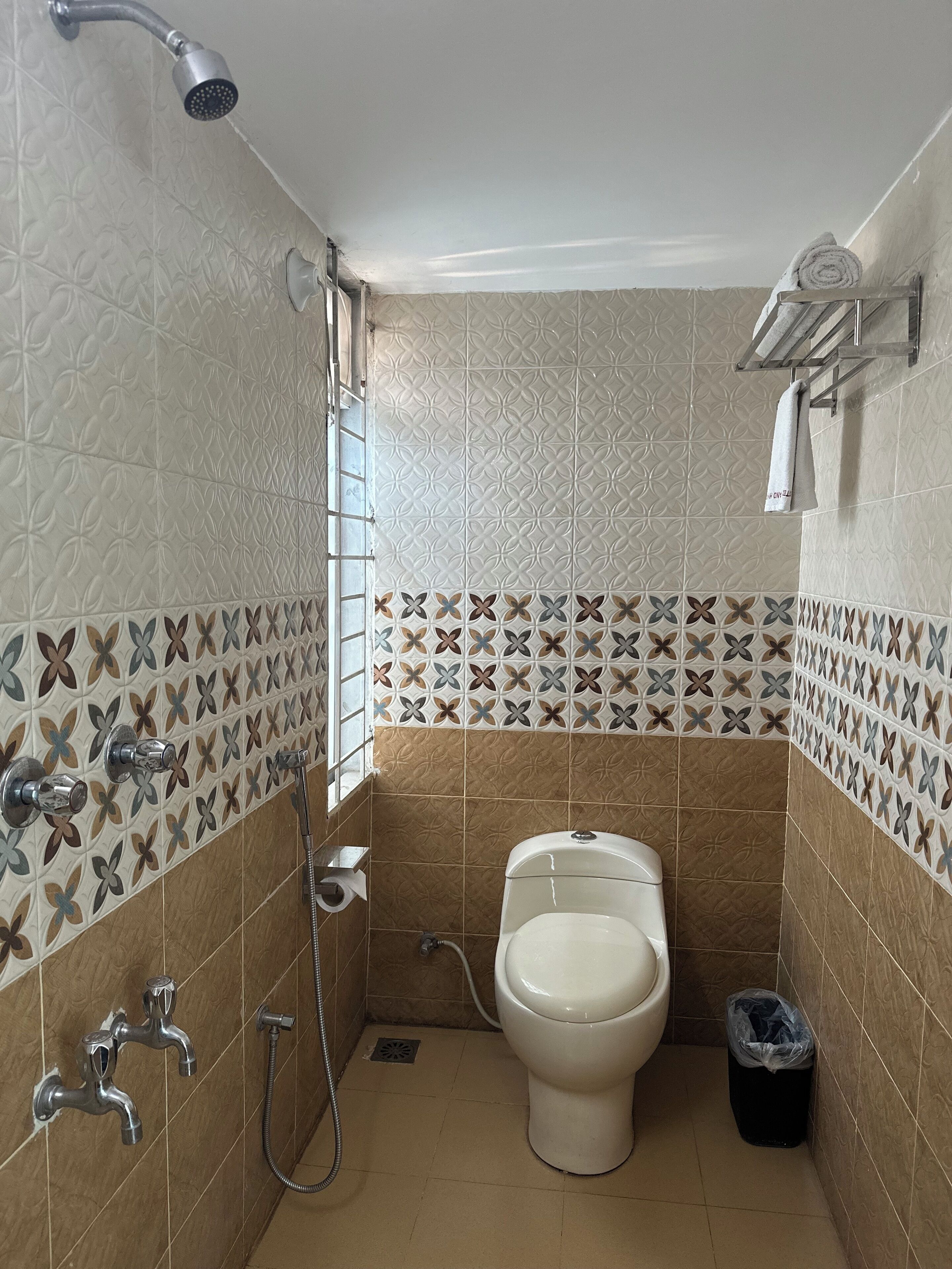 A bathroom with a toilet, shower, and sink.