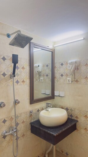 A bathroom with a shower, a sink, a mirror, and a hairdryer.