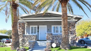 A stone house with a porch, palm trees, and a clear sky. - Campus Casita close to U of A and shopping (Tucson)