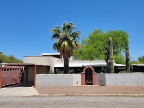 Ein Wohnhaus mit Garage, einer Palme und einem Kaktus.