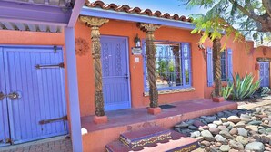 A building with a blue door, a number sign, and a stone pillar.