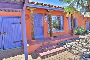 A building with a blue door, a number sign, and a stone pillar.