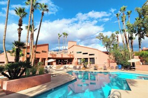 A swimming pool with lounge chairs, palm trees, and a building with a desert backdrop. - 2BR Desert Oasis Near Sabino Canyon With Pool/Spa (Tucson)