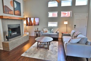 A living room with a fireplace, a sofa, a coffee table, and a television.
