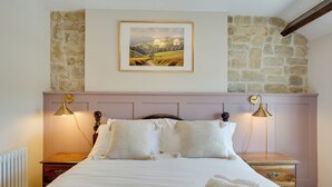 A neatly made bed with white linens and two lamps on either side. - The Coach House : Cosy Cottage Retreat (Bakewell)