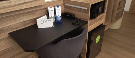 A modern office desk with a computer, a chair, and two water bottles.