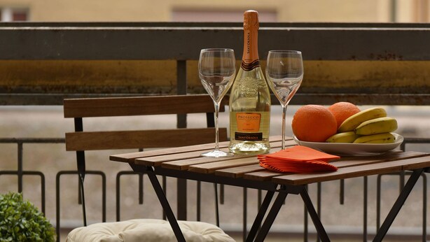 A table with a bottle of Prosecco, two glasses, and a plate of fruit. - Central Apartment Guisan in Paradiso (Paradiso)