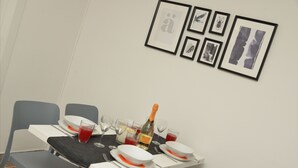 A dining table set with plates, glasses, and a bottle of champagne. - Central Apartment Guisan in Paradiso (Paradiso)
