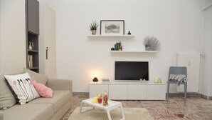A living room with a sofa, a coffee table, a TV, and a bookshelf. - Central Apartment Guisan in Paradiso (Paradiso)