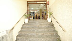 A staircase leading to a room with a patterned wall and a ceiling fan. - Hotel Aman Inn (New Delhi)