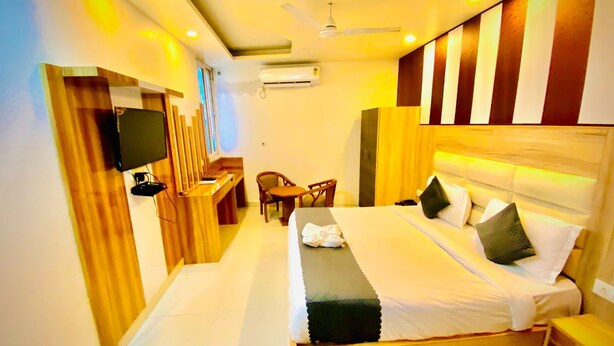A modern hotel room with a large bed, a desk, and a chair. - Hotel Aman Inn (New Delhi)