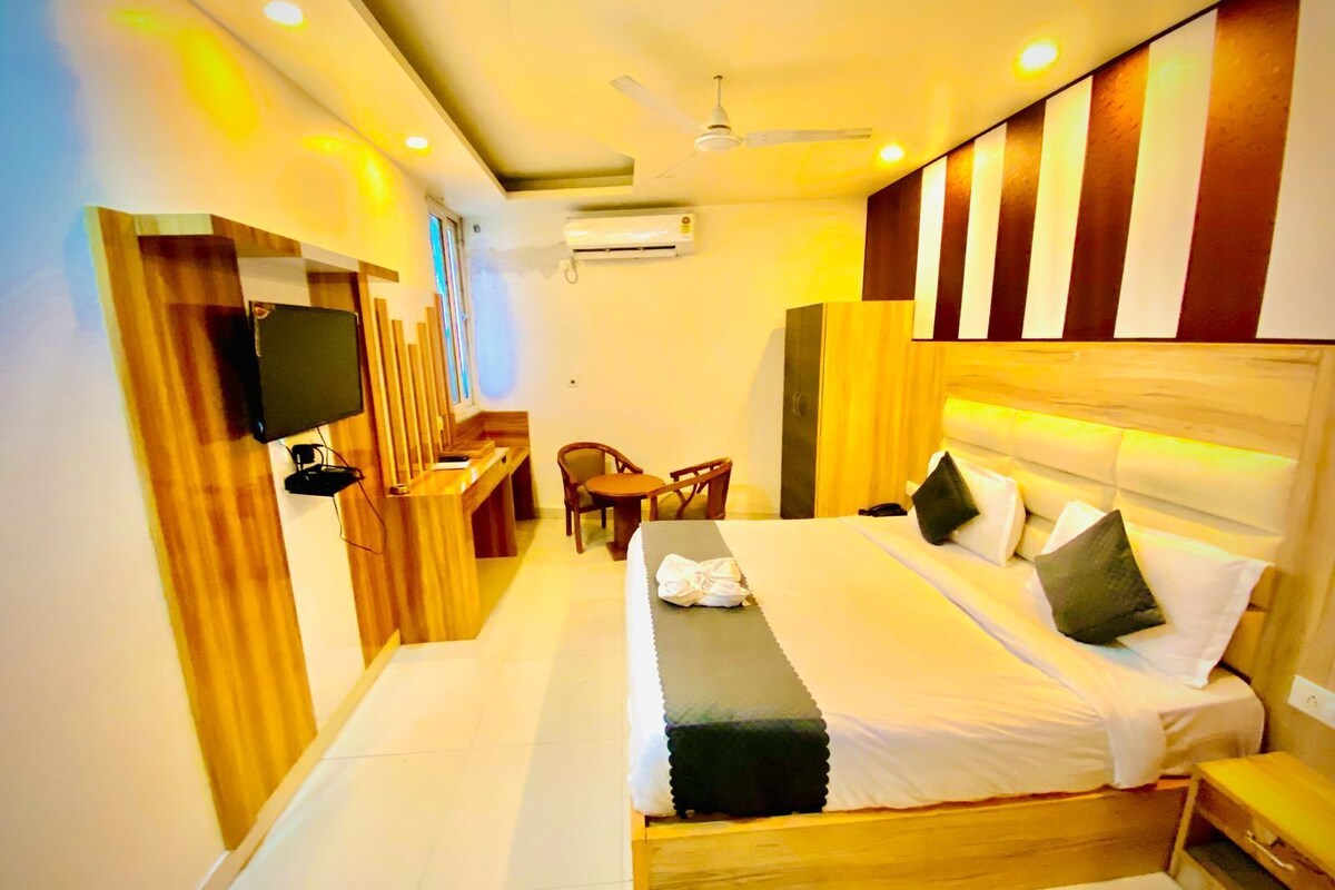 A modern hotel room with a large bed, a desk, and a chair.