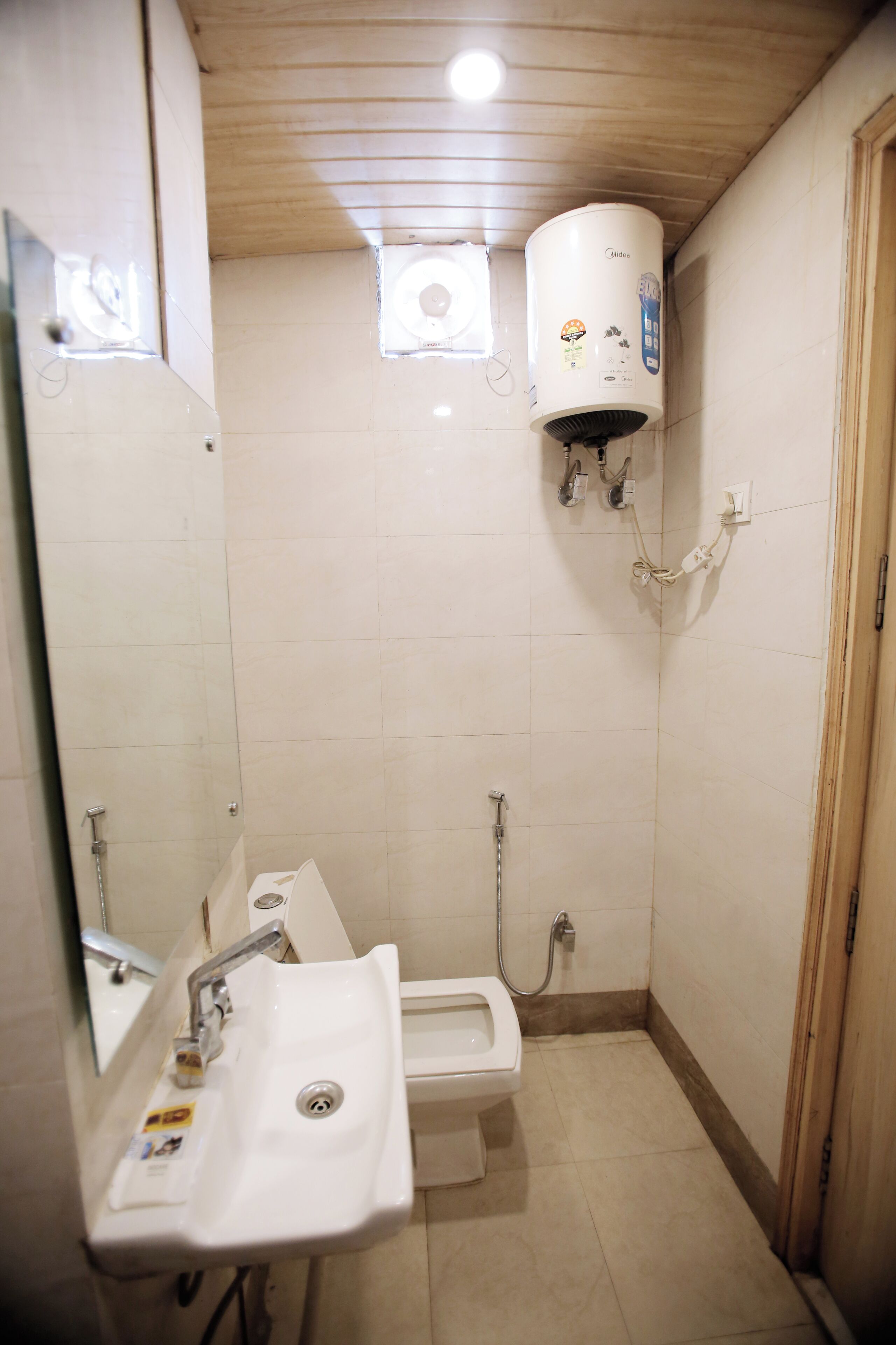 Un baño pequeño con lavamanos, inodoro y calentador de agua.