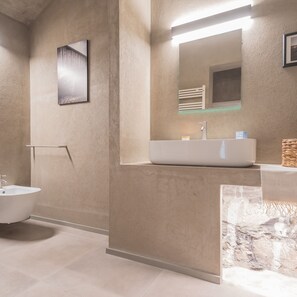 A modern bathroom with a freestanding bathtub, a large mirror, and a sink with a soap dispenser. - Urio s Castle Suites (Carate Urio)