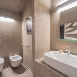 A modern bathroom with a white sink, a bidet, and a large mirror. - Gaia Suite Nearby Urio s Castle (Carate Urio)