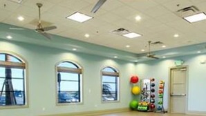 A spacious room with large windows, a ceiling fan, and exercise balls against the wall. - CG 9025 Shadow Mountain Epic Villa By Disney Theater Game Room Pool Spa (Davenport)