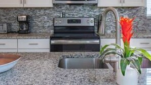 A kitchen with white cabinets, a microwave, a coffee maker, and a sink. - CG 1557 Mulligan Magical Retreat 5BR Pool Spa Near Disney (Davenport)