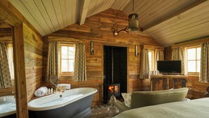 A cabin interior with a large bathtub, a fireplace, a television, and a cozy seating area. - THE PIG at Bridge Place - Kent (Canterbury)