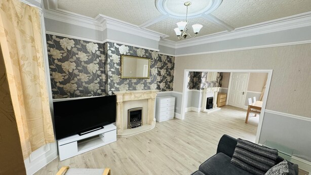 A living room with a fireplace, a television, and a sofa. - Entire 4-bed House in Sunderland (Sunderland)