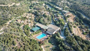 An aerial view of a resort with multiple buildings, a swimming pool, and surrounding greenery. - Ecovillage with swimming-pool in Teulada (Teulada)