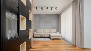 Una sala de estar moderna con un sofá modular, un mueble empotrado para entretenimiento y piso de madera.