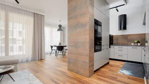 Una cocina moderna con armarios grises, una isla central y un comedor con mesa y sillas.