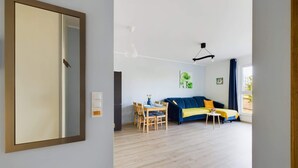 Un salon moderne comprenant un coin repas, un canapé et un grand miroir.