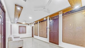 A spacious hallway with a ceiling fan, a sofa, and a door with a window. - BELLA VAGUES (Chennai)