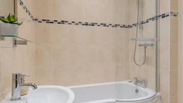 A bathroom with a bathtub, a sink, and a shower.